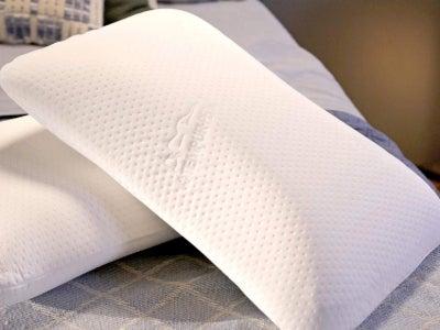 Two TEMPUR-Symphony pillows on a plaid bedspread.