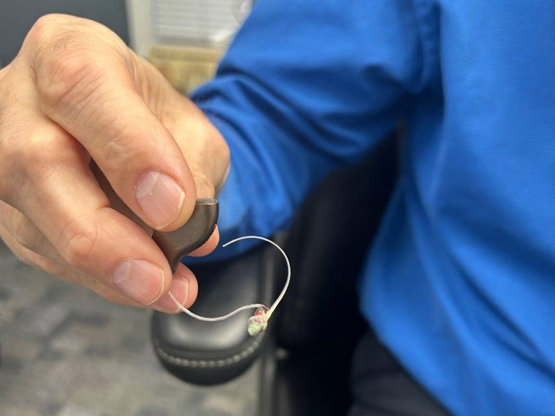 A person holding a Starkey hearing aid