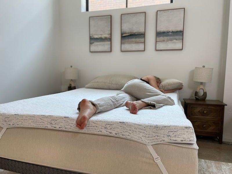 A woman lying on her side on the ViscoSoft Select High Density mattress topper