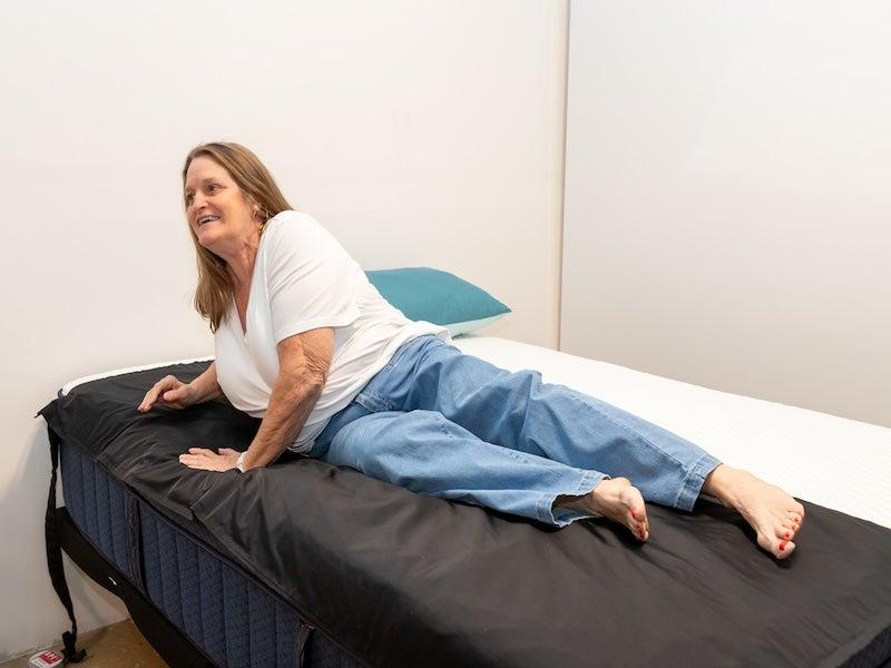 A woman rolls over onto her side on the Brooklyn Bedding Aurora Luxe mattress