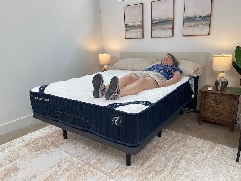 A woman lies on her back on the DreamCloud Classic Hybrid