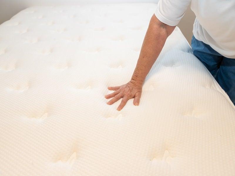 Woman pressing down on the surface of the Brooklyn Bedding Signature mattress