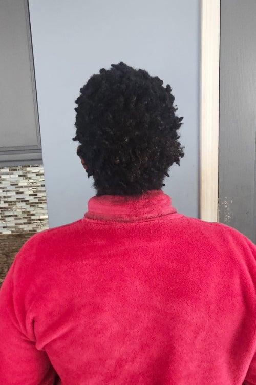 The back of a woman's head of hair, showing longer, thicker hair