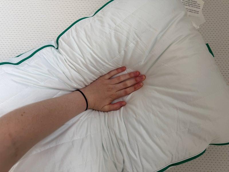 A person presses their hand into the Brooklinen Marlow pillow to show its plushness.