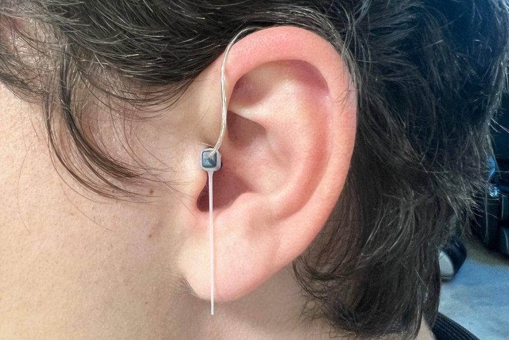 Jabra hearing aid with sports lock out of place in man's left ear