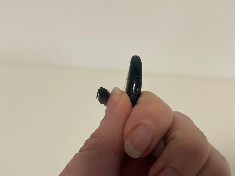 A hand holding a Signia hearing aid