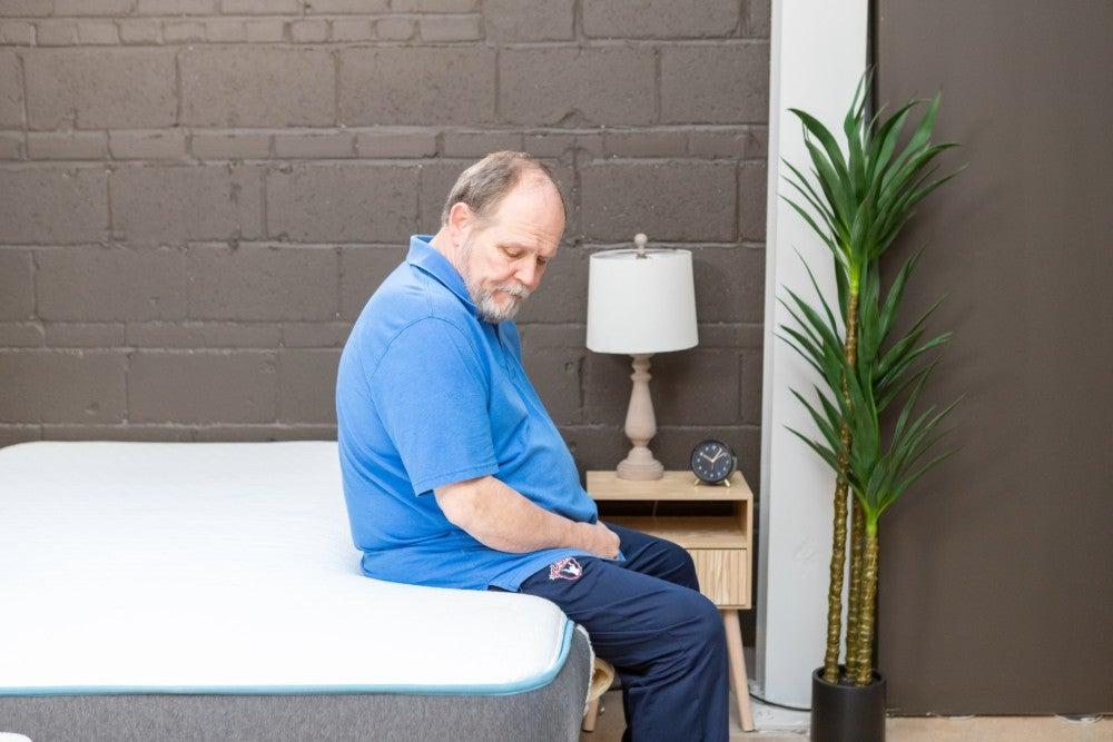 A man sitting on the edge of the Bear Original mattress