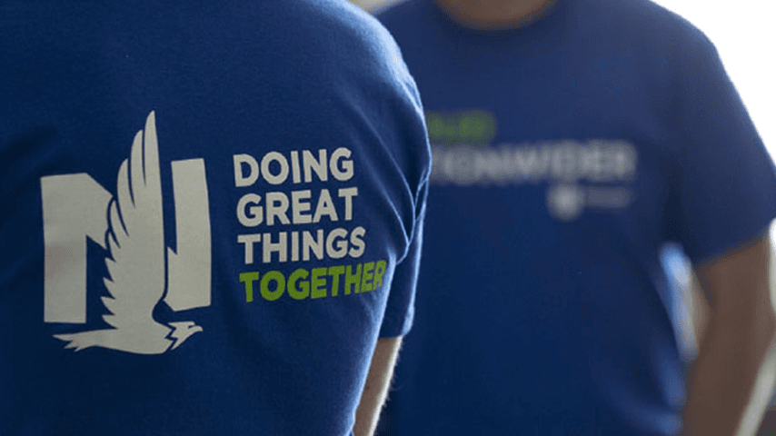 Two people are wearing blue Nationwide shirts, where the shirt has the company's logo and the shirt says 'Doing great things together.'