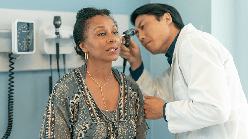 doctor examining woman's ear