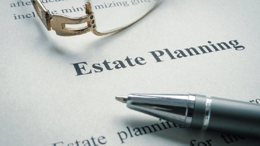 Close up of the words 'estate planning' on a document with glasses close by.