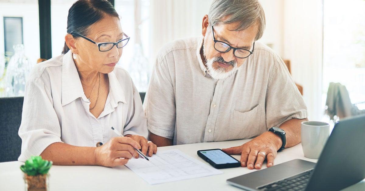 A senior woman of what looks to be native descent is looking at a qualified health plan with her partner who is a man. What is a QHP? Find out how these plans may help you get the coverage you need before you become Medicare-eligible.