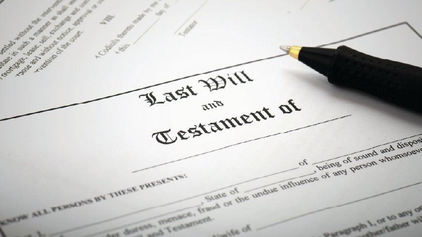 Close up of a last will and testament document with a pen resting on top.