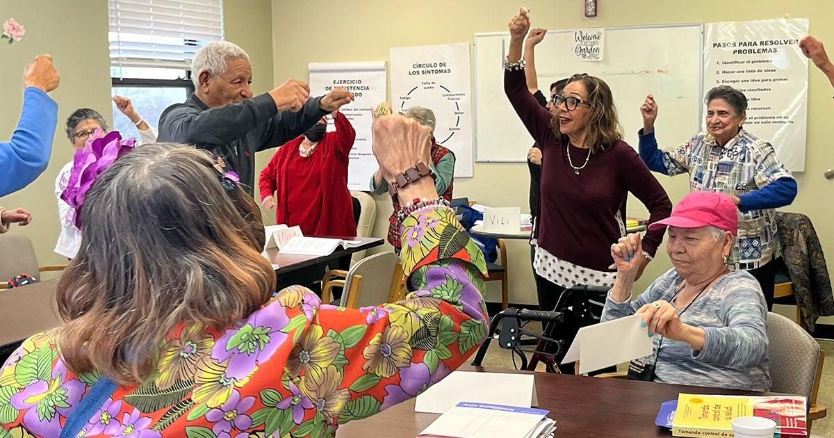 A community health worker leading a group of older adults in an exercise class