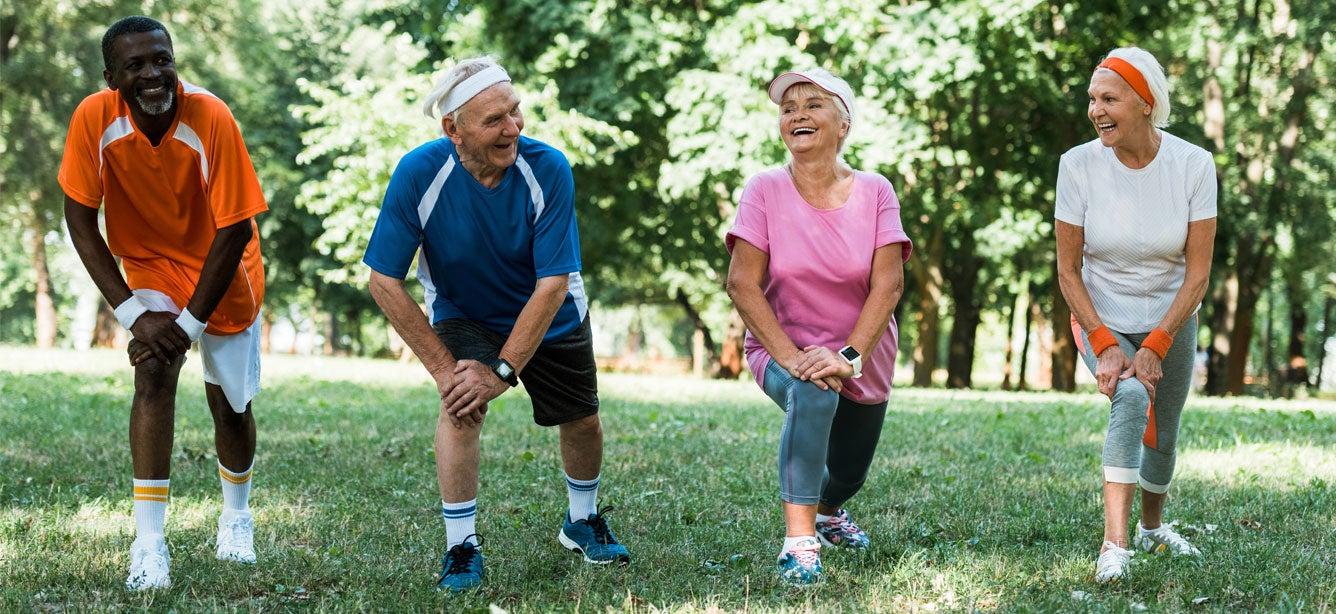 two older men and two older women stretching outdoors