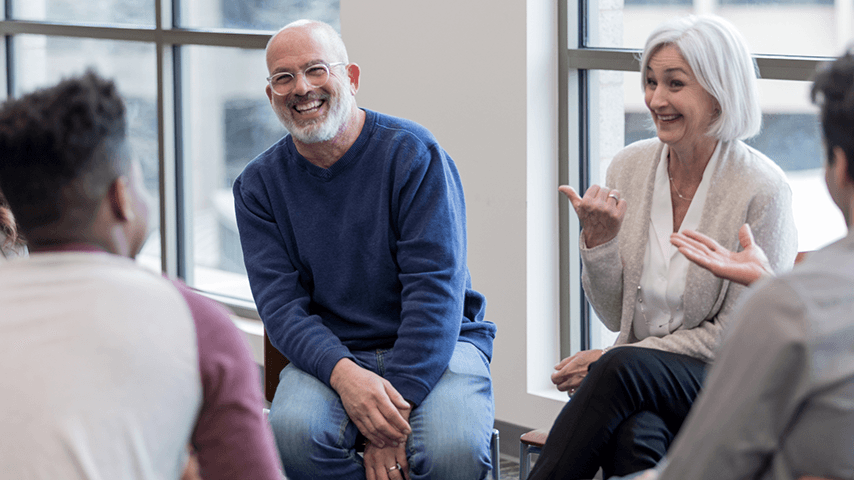 smiling older adults seated in circle